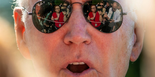 Members of the media are visible in the sunglasses of President Biden as he speaks on the South Lawn of the White House Monday, May 30, 2022.