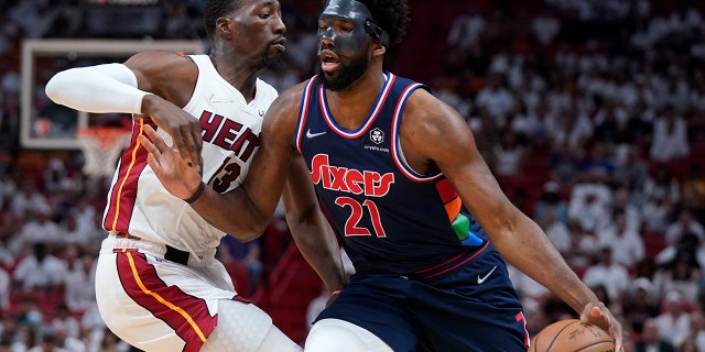 Philadelphia 76ers center Joel Embiid (21) drives up against Miami Heat center Bam Adebayo (13) during the first half of Game 5 of an NBA basketball second-round playoff series, Tuesday, May 10, 2022, in Miami. 