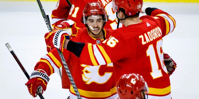 Calgary Flames forward Johnny Gaudreau, left, and defenseman Nikita Zadorov celebrates defeating the Dallas Stars in overtime NHL playoff hockey action in Calgary, Alberta, Sunday, May 15, 2022.