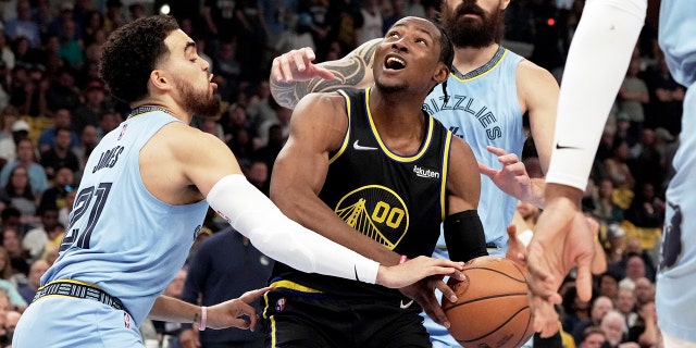 Golden State Warriors' Jonathan Kuminga (00) goes up for a basket as Memphis Grizzlies' Tyus Jones (21) defends in the first half of Game 5 of an NBA basketball second-round playoff series Wednesday, 할 수있다 11, 2022, in Memphis, Tenn.