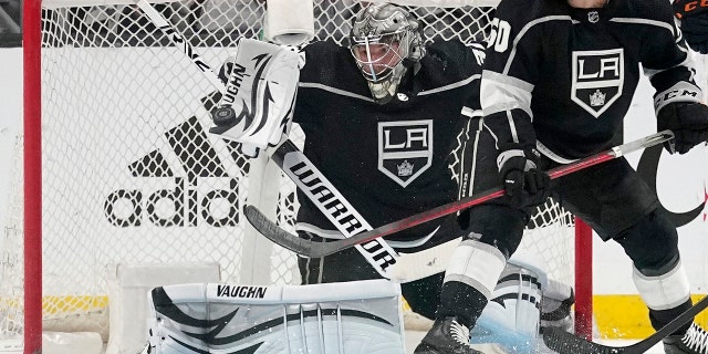 Los Angeles Kings goaltender Jonathan Quick, left, makes a pad save as defenseman Sean Durzi watches during the second period in Game 4 of an NHL hockey Stanley Cup first-round playoff series against the Edmonton Oilers Sunday, May 8, 2022, in Los Angeles.