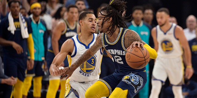 Grizzlies guard Ja Morant is defended by Golden State Warriors' Jordan Poole during the playoff series Tuesday, May 3, 2022, in Memphis, Tennessee.