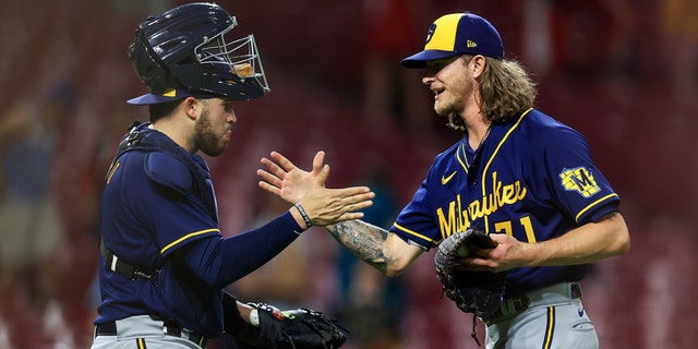 Milwaukee Brewers' Victor Caratini, left, high-fives Josh Hader after the final out against the Cincinnati Reds in Cincinnati on May 10, 2022.