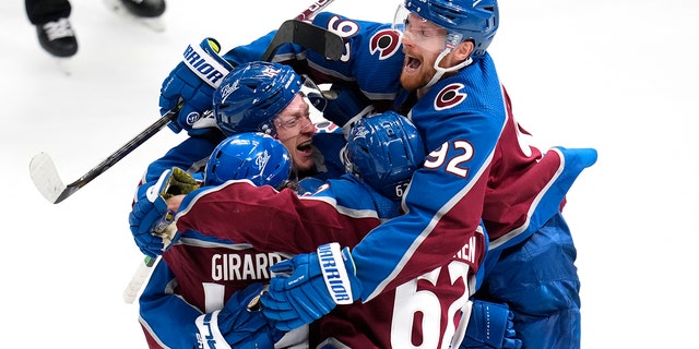 Colorado Avalanche defenseman Josh Manson is congratulated by teammates after scoring in overtime against the St. Louis Blues in Game 1 of the second-round playoff series Tuesday, 五月 17, 2022, デンバーで.