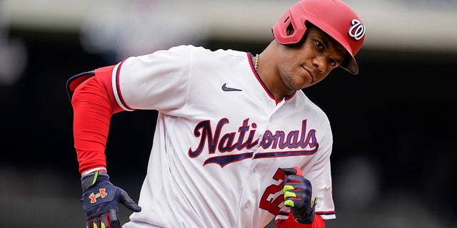 Washington Nationals' Juan Soto looks into the New York Mets dugout as he rounds the bases for his solo home run during the ninth inning of a baseball game at Nationals Park, Thursday, May 12, 2022, in Washington. 