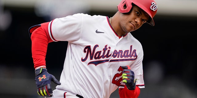 Washington Nationals' Juan Soto looks into the New York Mets dugout as he rounds the bases for his solo home run during the ninth inning of a baseball game at Nationals Park, Thursday, May 12, 2022, in Washington.