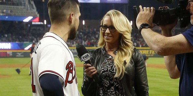 Centerfielder Ender Inciarte #11 of the Atlanta Braves is interviewed by Fox Sports South field reporter Kelsey Wingert after Inciarte's game winning squeeze bunt during the game against the New York Mets at SunTrust Park on April 21, 2018 in Atlanta, Georgia. 