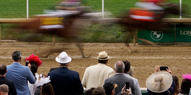 Fans watch the first race of the day at Churchill Downs Saturday, May 7, 2022, in Louisville, Ky. The 148th running of the Kentucky Derby horse race is scheduled for later in the day. 