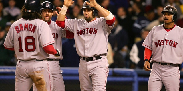 Johnny Damon (18) of the Boston Red Sox is congratulated by Kevin Millar (15), Bill Mueller (11) and Orlando Cabrera (44) after hitting a grand slam  in the second inning against the New York Yankees during Game 7 of the American League Championship Series Oct. 20, 2004 at Yankee Stadium in the Bronx.