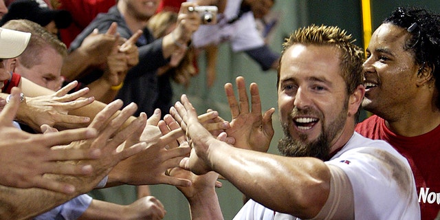 Kevin Millar, left, and Manny Ramirez of the Red Sox take a victory lap around the field following the Red Sox' series-clinching extra inning victory.