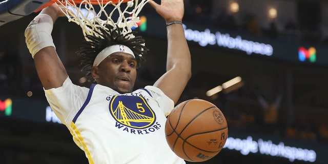 Golden State Warriors center Kevon Looney (5) dunks over Dallas Mavericks guard Luka Doncic, right, and forward Maxi Kleber during the second half of Game 2 of the NBA basketball playoffs Western Conference finals in San Francisco, Friday, May 20, 2022.