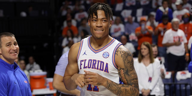 FILE - Florida forward Keyontae Johnson, center, smiles after being introduced as a starter before an NCAA college basketball game against Kentucky, March 5, 2022, in Gainesville, Fla.
