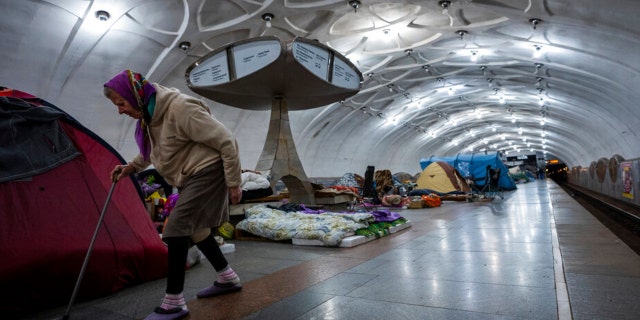 An elderly woman walks inside a metro station being used as a bomb shelter in Kharkiv, Ukraine, Thursday, May 12, 2022.