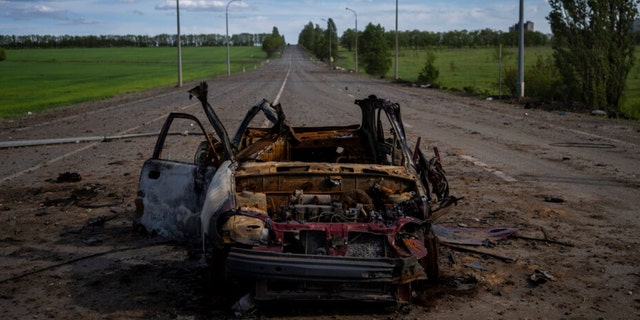 A destroyed vehicle lies in the middle of a road in north Kharkiv, east Ukraine, Friday, May 13, 2022. 
