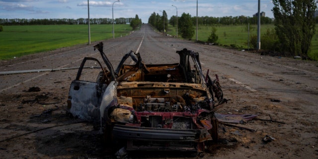 A destroyed vehicle lies in the middle of a road in north Kharkiv, east Ukraine, Friday, May 13, 2022. 