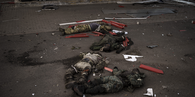 Les corps d'hommes non identifiés, supposés être des soldats russes, disposés en Z, symbole de l'invasion russe, reposent près d'un village récemment repris par les forces ukrainiennes à la périphérie de Kharkiv, en Ukraine, le lundi 2 mai.