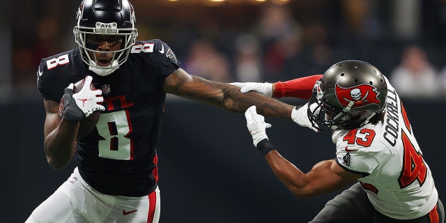 Kyle Pitts (8) of the Atlanta Falcons carries the ball after a reception as Ross Cockrell (43) of the Tampa Bay Buccaneers pursues at Mercedes-Benz Stadium Dec. 5, 2021, in Atlanta.