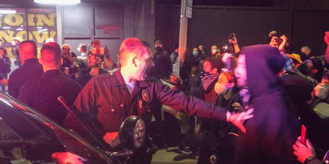 Demonstrators confront police officers near Pershing Square after protesting outside of the U.S. Courthouse in response to leaked draft of the Supreme Court's opinion to overturn Roe v. Wade, in Los Angeles, Tuesday, May 3, 2022. (AP Photo/Ringo H.W. Chiu)