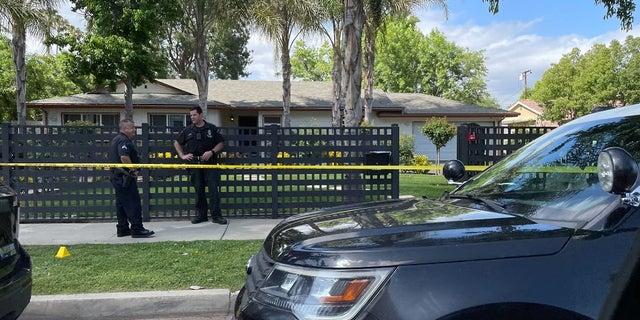 Los Angeles police officers stand outside a home where a mother allegedly killed her three children on Mother's Day.