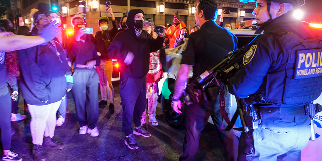 Demonstrators confront police officers near Pershing Square after protesting outside the U.S. Courthouse in response to leaked draft of the Supreme Court's opinion to overturn Roe v. Wade in Los Angeles, Tuesday, May 3, 2022. (AP Photo/Ringo H.W. Chiu)