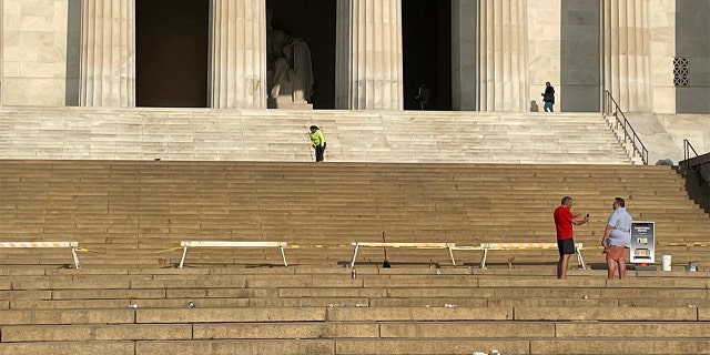 Workers clean the steps of the Lincoln Memorial in Washington Saturday, May 21, 2022, after broken bottles and spilled alcohol was found following a graduation celebration.