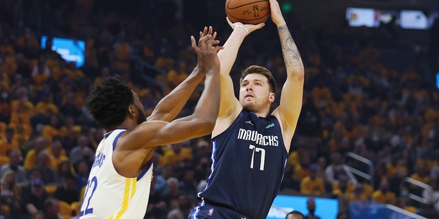 Dallas Mavericks guard Luka Doncic (77) shoots against Golden State Warriors forward Andrew Wiggins during the first half of Game 2 of the NBA basketball playoffs Western Conference finals in San Francisco, Vrydag, Mei 20, 2022.