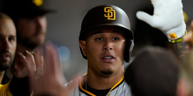 San Diego Padres' Manny Machado is congratulated by his teammates after hitting a home run in the fourth inning of a May 5, 2022 game against the Miami Marlins in San Diego. 