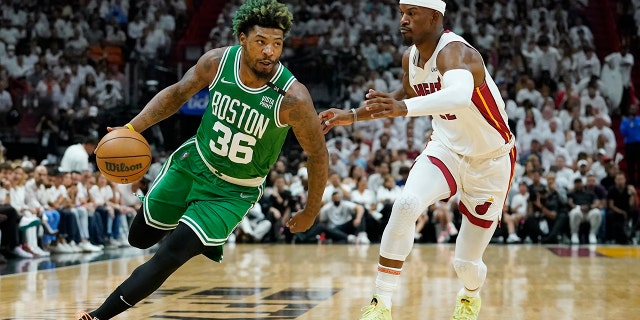 Boston Celtics guard Marcus Smart (36) dribbles around Miami Heat forward Jimmy Butler (22) during the first half of Game 2 of the NBA basketball Eastern Conference finals playoff series, giovedi, Maggio 19, 2022, a Miami.
