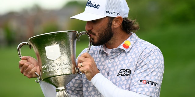 Max Homa kisses the trophy after winning the Wells Fargo Championship Golf Tournament, Sunday, May 6, 2022, at TPC Potomac's Avenell Farm Golf Club, Md. 