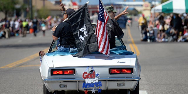 Classic convertibles like the 1967 Chevrolet Camaro SS provide the perfect perch for veterans to receive salutations from the crowd in Commerce City, Colorado, home to the state's largest Memorial Day parade.