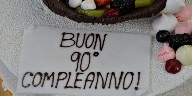 Meri Mion's 90th birthday cake included white frosting, chocolate icing, decorative candy bars and fresh fruit.