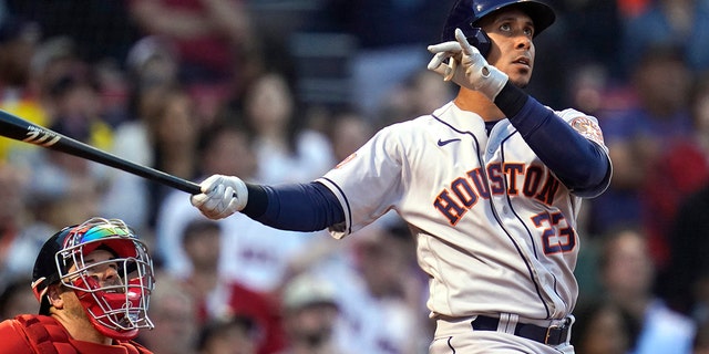 Houston Astros' Michael Brantley watches his two-run home run alongside Boston Red Sox catcher Kevin Plawecki during the second inning of a baseball game at Fenway Park, Tuesday, May 17, 2022, in Boston.