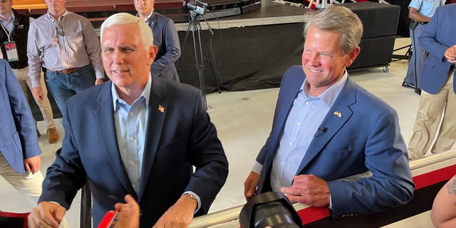 Former Vice President Mike Pence and Republican Gov. Brian Kemp shake hands with supporters after Pence headlined a primary eve rally for Kemp, on May 23, 2022, in Cobb County, Georgia.