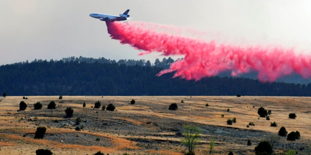 A firefighting airplane drops slurry on a wildfire near Las Vegas, N.M., on Tuesday, May 3, 2022. 
