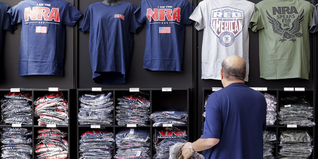 A convention attendee looks at NRA branded shirts for sale at the NRA Store at the NRA Annual Meeting in Houston, テキサス, 木曜日に, 五月 26.
