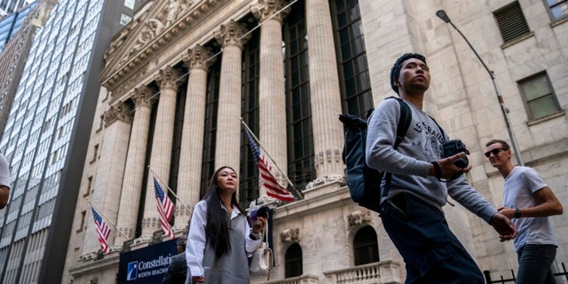 Pedestrians pass the New York Stock Exchange, May 5, 2022, in the Manhattan borough of New York.