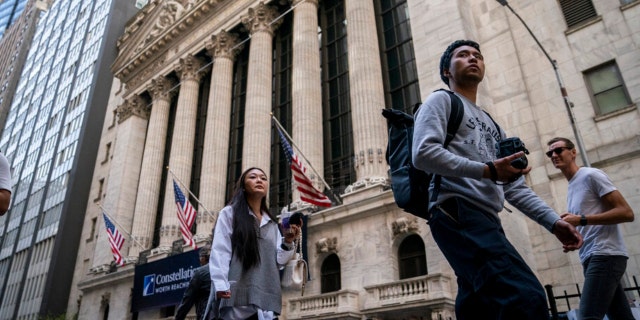 Pedestrians pass the New York Stock Exchange, May 5, 2022, in the Manhattan borough of New York.