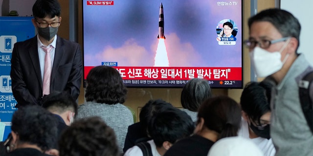 La gente ve la televisión que muestra una imagen del lanzamiento de un cohete norcoreano durante un programa de noticias el sábado 7 de mayo en Seúl, Corea del Sur, en la estación de tren de Seúl.