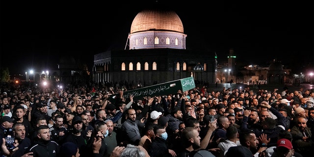 Mourners carry the coffin of Palestinian, Waleed Shareef, 21, during his funeral at the Al Aqsa Mosque compound in Jerusalem's Old City, Monday, May 16, 2022. Shareef died Saturday from a head wound sustained last month after Israeli police fired rubber bullets at stone-throwing Palestinian demonstrators during violence at the Al Aqsa Mosque compound, in Jerusalem's Old City. 