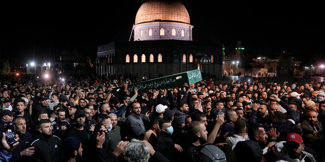 Mourners carry the coffin of Palestinian, Waleed Shareef, 21, during his funeral at the Al Aqsa Mosque compound in Jerusalem's Old City, Monday, May 16, 2022. Shareef died Saturday from a head wound sustained last month after Israeli police fired rubber bullets at stone-throwing Palestinian demonstrators during violence at the Al Aqsa Mosque compound, in Jerusalem's Old City.
