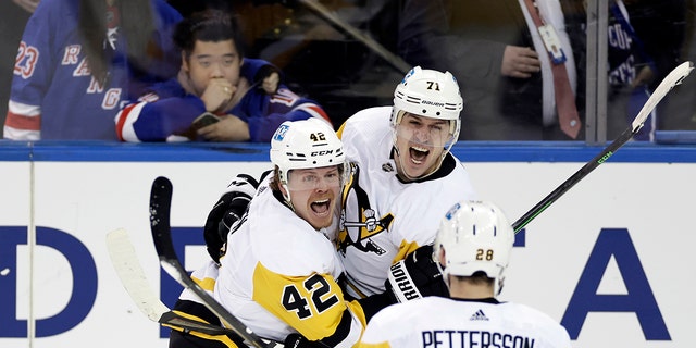 Pittsburgh Penguins center Evgeni Malkin (71) celebrates with teammates after scoring against the New York Rangers during the third overtime in Game 1 of an NHL hockey Stanley Cup first-round playoff series, Tuesday, May 3, 2022, in New York. The Penguins won 4-3. 