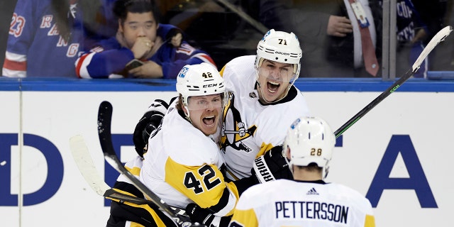 Pittsburgh Penguins center Evgeni Malkin (71) celebrates with teammates after scoring against the New York Rangers during the third overtime in Game 1 of an NHL hockey Stanley Cup first-round playoff series, Tuesday, May 3, 2022, in New York. The Penguins won 4-3.