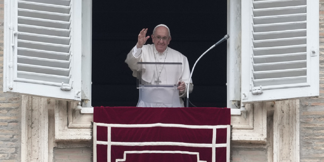 Pope Francis waves to faithful from his studio window overlooking St. Peter's Square to recite the Regina Coeli prayer at the Vatican on Sunday, May 1.