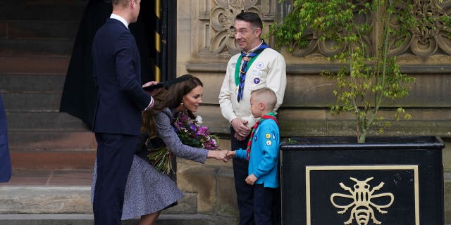 William and Middleton speak to Archie McWilliams, aged 7, from the First Longford Scout Group in Stretford, and his uncle Greater Manchester West Scouts' County Commissioner Andy Farrell, as they leave after attending the launch of the Glade of Light Memorial, outside Manchester Cathedral.