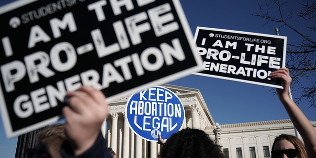 Pro-life activists try to block the sign of a pro-choice activist during the 2018 March for Life Jan. 19, 2018, in Washington, DC