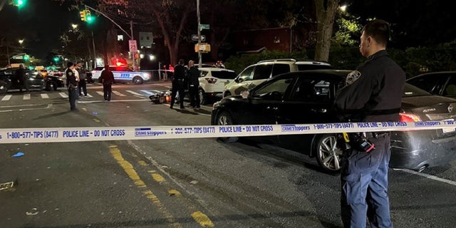 Authorities in Queens secure the scene near Zhiwen Yan's scooter where he was shot and killed. 