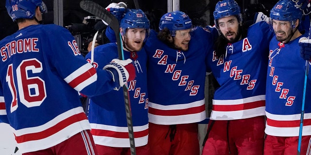 New York Rangers center Mika Zibanejad, second from right, celebrates after scoring on Carolina Hurricanes goaltender Antti Raanta during the first period of Game 6 of an NHL hockey Stanley Cup second-round playoff series, Saturday, May 28, 2022, in New York. (AP Photo/John Minchillo)