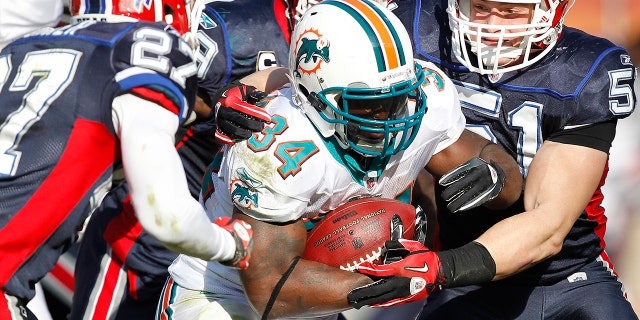 Ricky Williams (34) of the Miami Dolphins is tackled by Paul Posluszny (51) and Reggie Corner (27) of the Buffalo Bills Dec. 19, 2010, at Sun Life Stadium in Miami. 