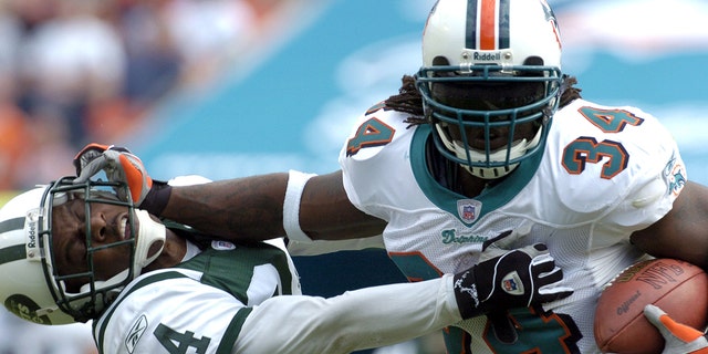Miami Dolphins running back Ricky Williams rushes to midfield Dec. 28, 2003, at Pro Player Stadium iniMiami.