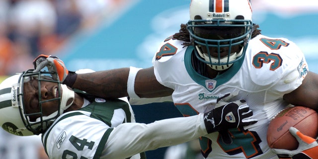 Miami Dolphins running back Ricky Williams rushes to midfield Dec. 28, 2003, at Pro Player Stadium iniMiami.